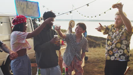 Happy-Multiethnic-Friends-Dancing-with-Drinks-at-Summer-Festival